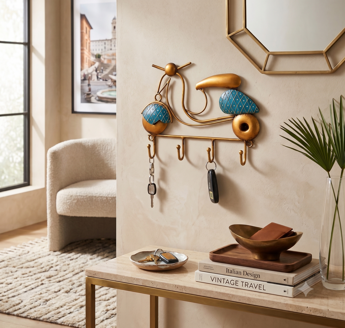 A decorative wall-mounted key rack shaped like a stylized scooter in gold and turquoise blue, shown hanging in a modern entryway with keys, a mirror, chair, and console table.