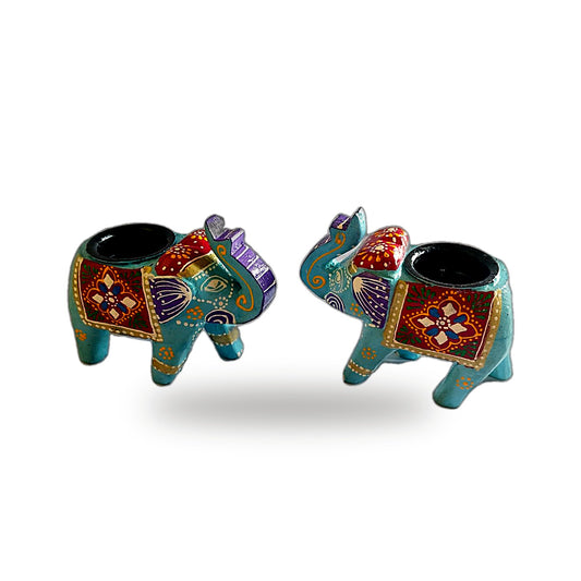 Two small decorative elephant-shaped candle holders with turquoise bodies and colorful hand-painted patterns in red, purple, gold, and orange, shown on a white background.